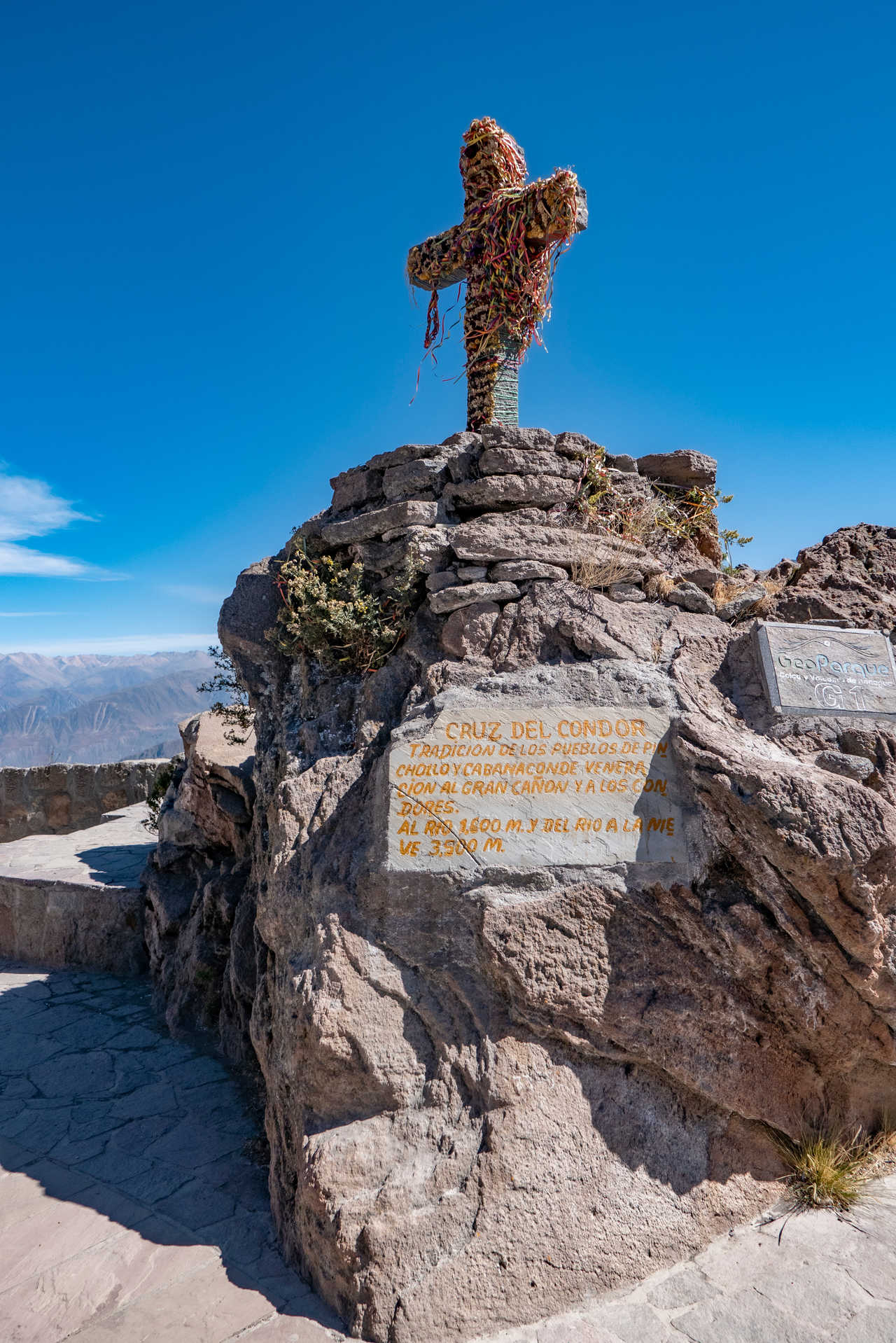 Gros plan sur la croix ornée et la plaque de pierre au belvédère Cruz del Condor, Canyon de Colca, Pérou.