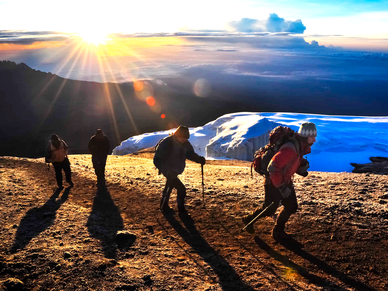 Groupe de randonneurs durant l'ascension finale du Kilimandjaro au lever de soleil en Tanzanie