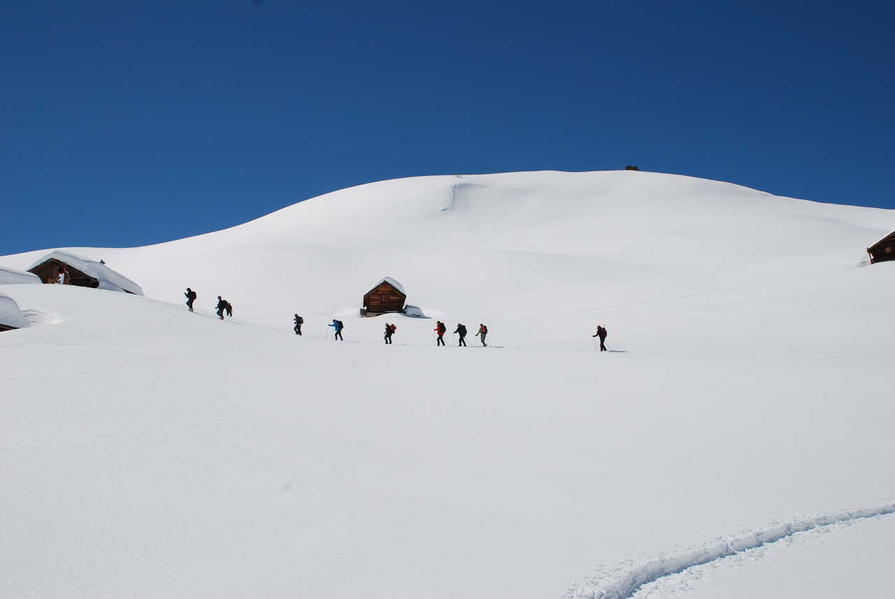 groupe de randonneurs en pleine randonnée entre des chalets au sud est de la France dans les Alpes