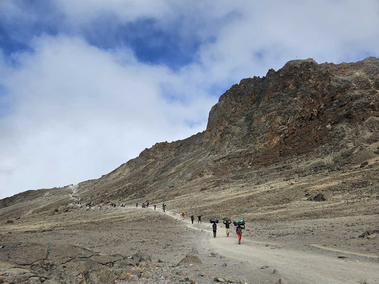 Groupe de randonneurs et porteurs en direction du camp Barafu pendant l'ascension du Kilimandjaro en Tanzanie