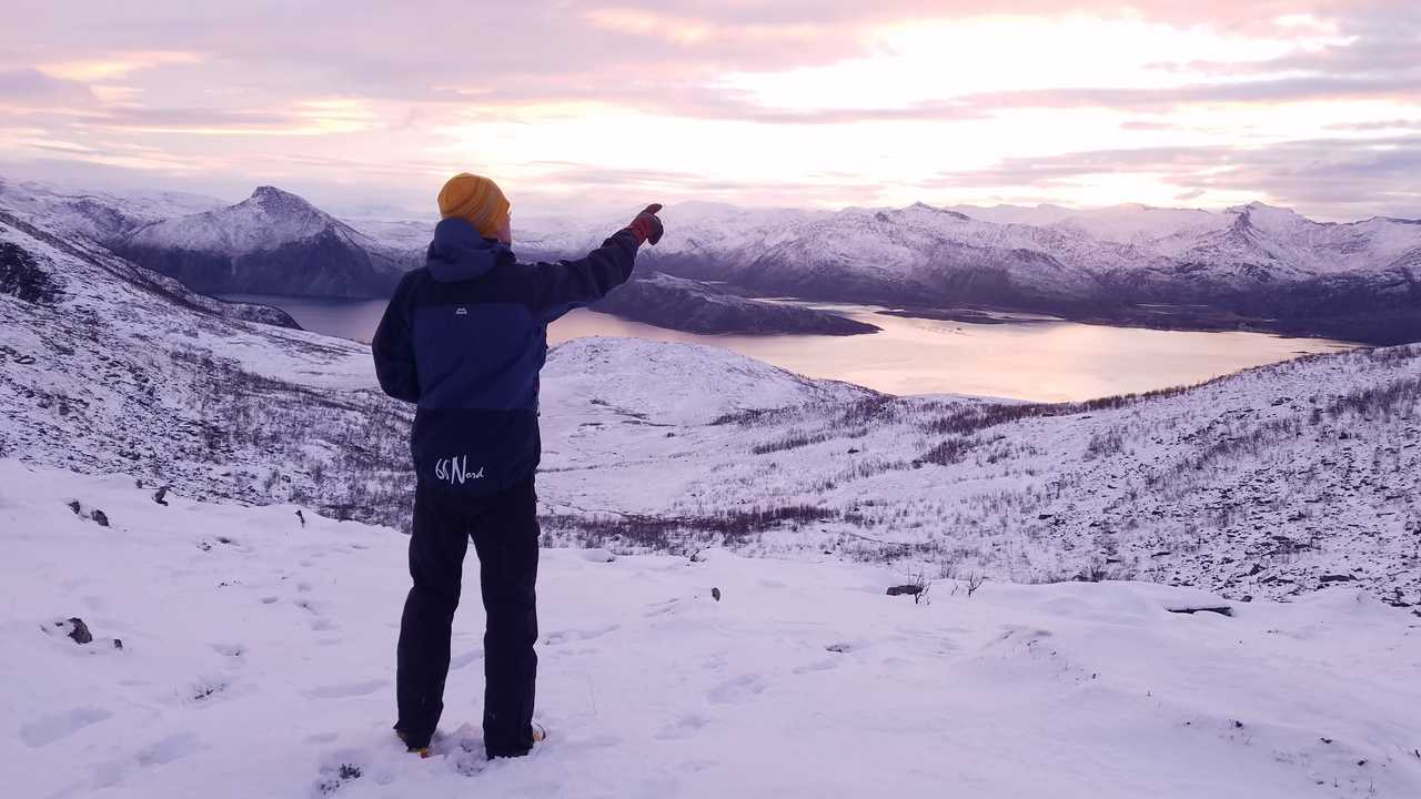 Guide qui admire la vue devant un lac en Norvège