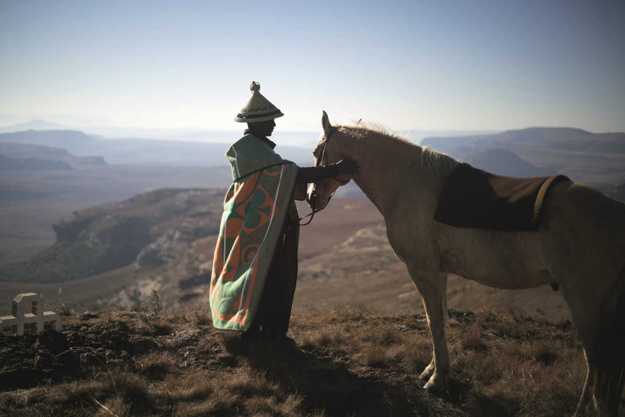 Homme du Lesotho avec son poney dans les montagnes