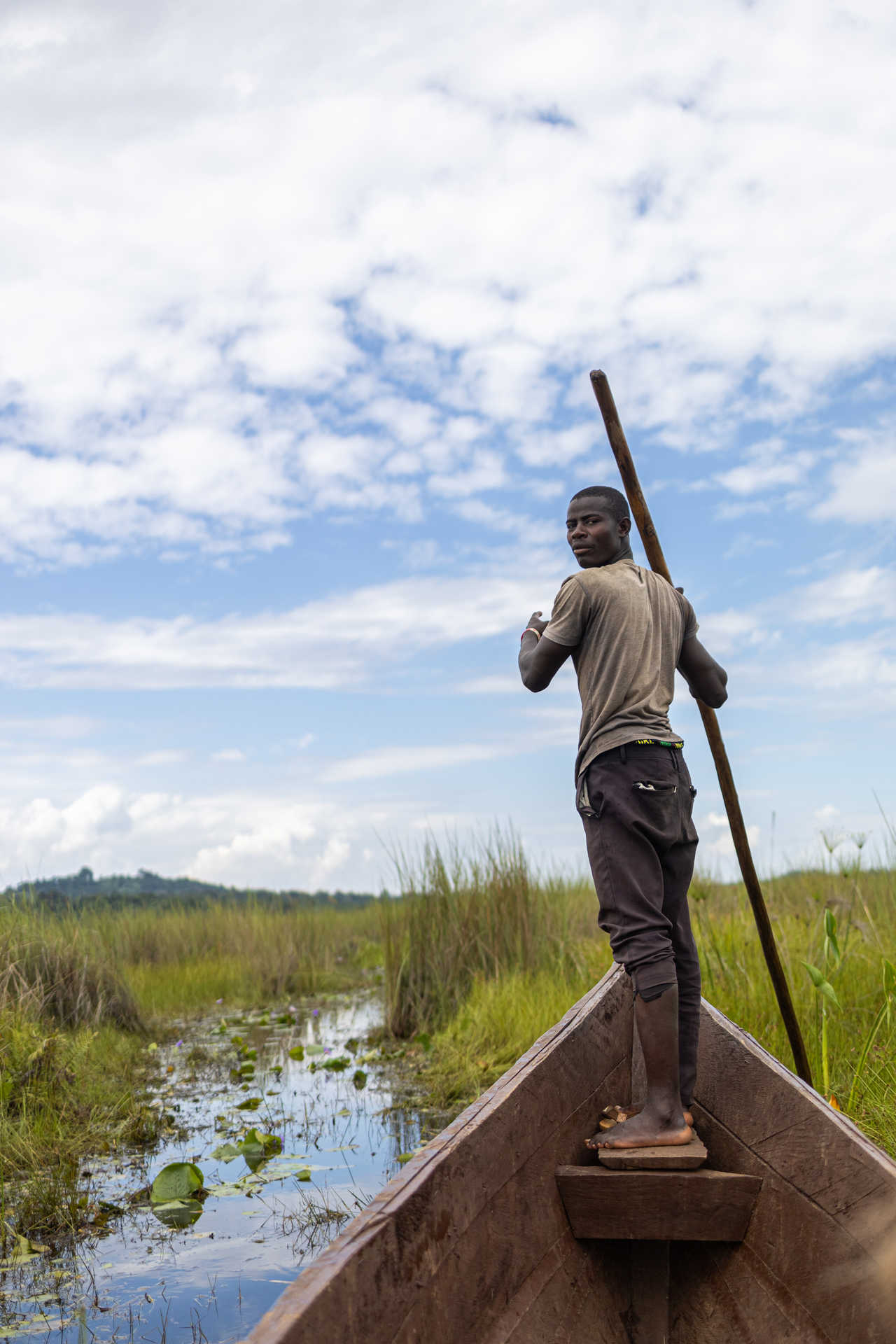 homme qui dirige une barque sur un fleuve en Ouganda
