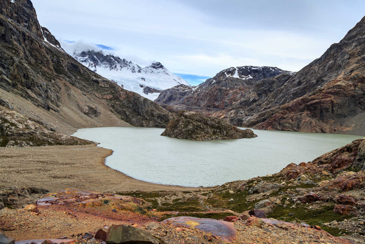 Le lac glaciaire de la Laguna Pollone avec son îlot rocheux et le glacier en arrière-plan lors d'un trek près d'El Chaltén en Patagonie argentine.