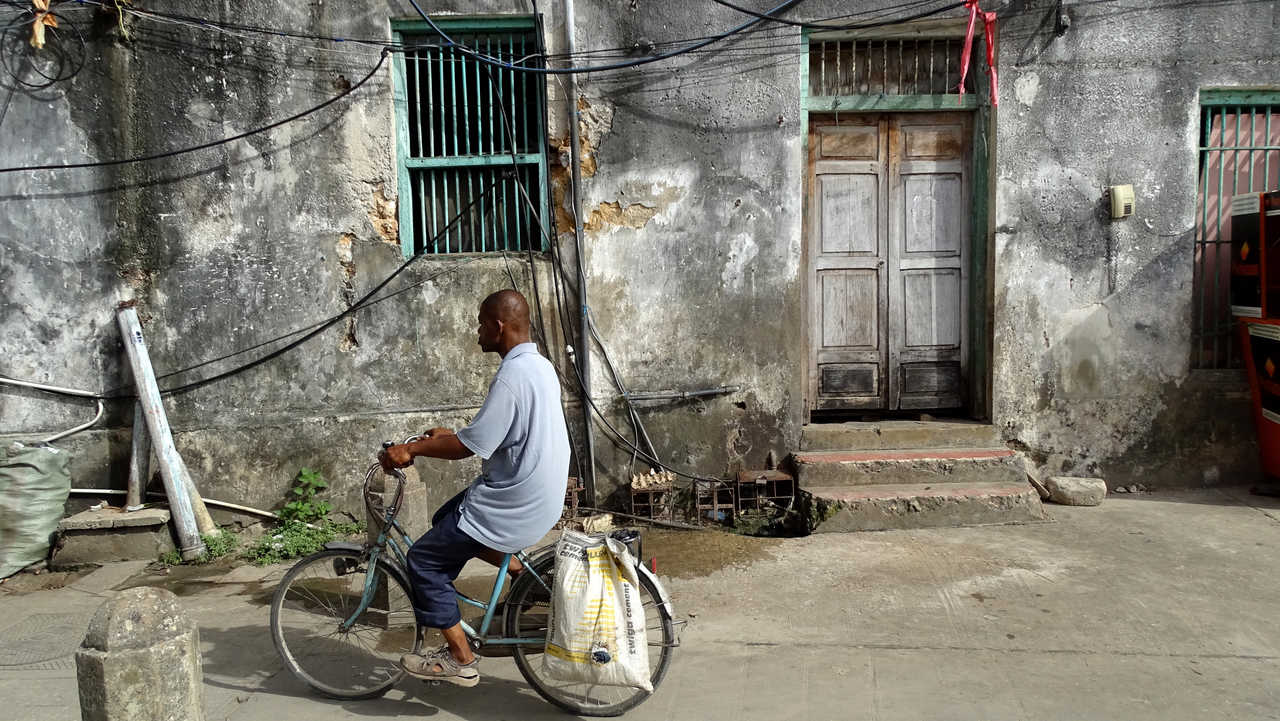 Local sur sa petite moto dans la ville de Stone Town à Zanzibar