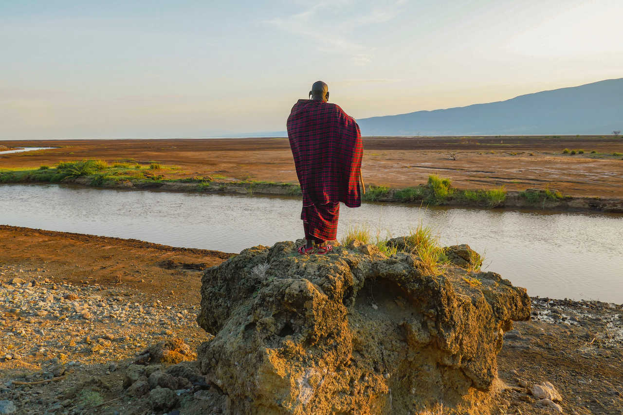 Masai dans sa tenue traditionnelle en train d'observe le lac Natron en Tanzanie