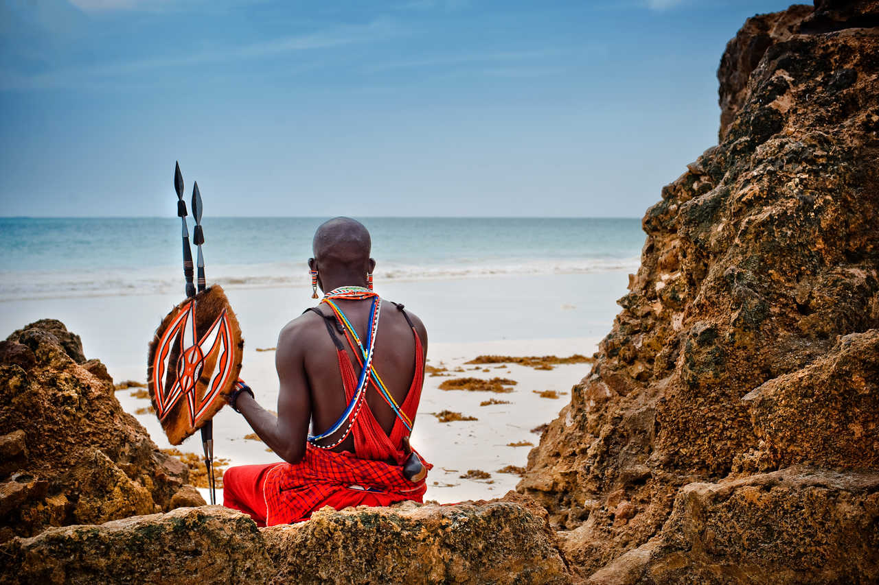 Masaï sur une plage de sable blanc au bord de l'océan Indien