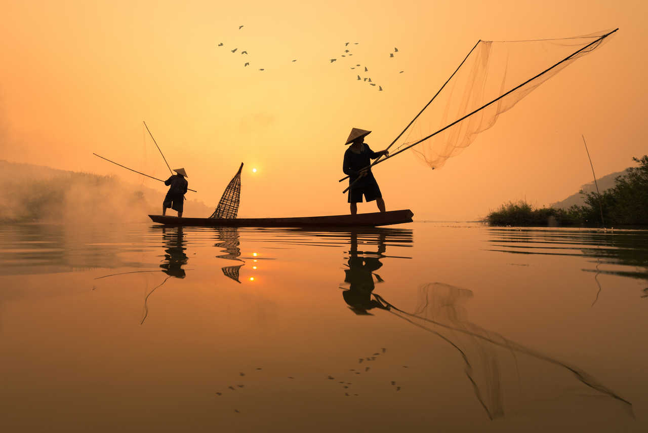 pécheurs  entrain de pêcher sur une barque dans la rivière Mekong un matin à Nongkhai, Thaïlande