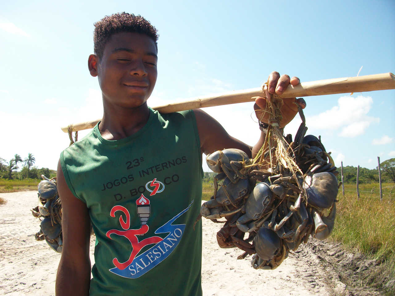 Pêcheurs tenant des crabes sur une plage au Brésil