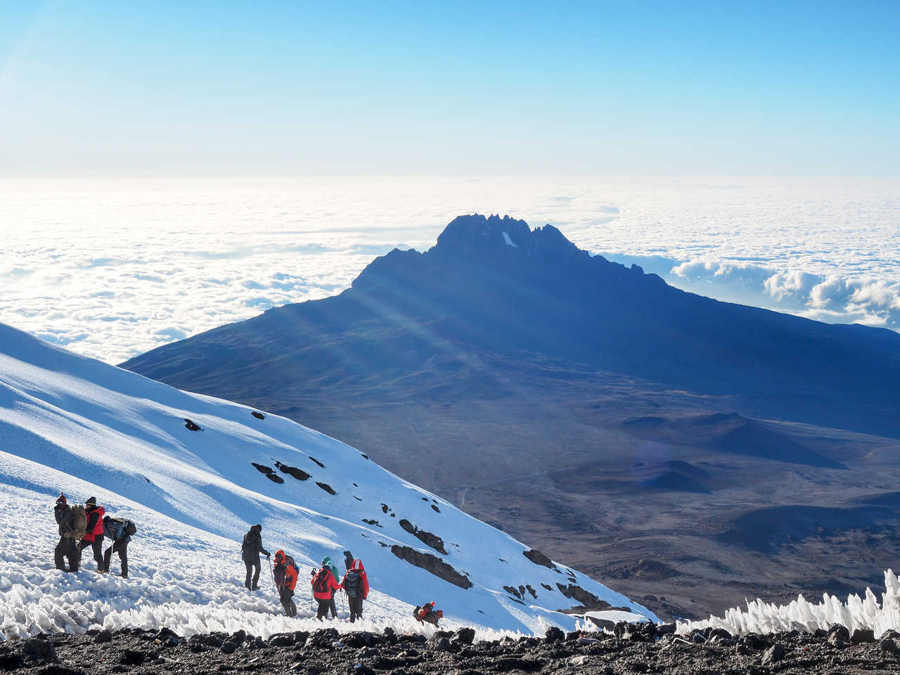 Petit groupe de randonneurs dans la neige lors de l'ascension du Kilimandjaro en Tanzanie