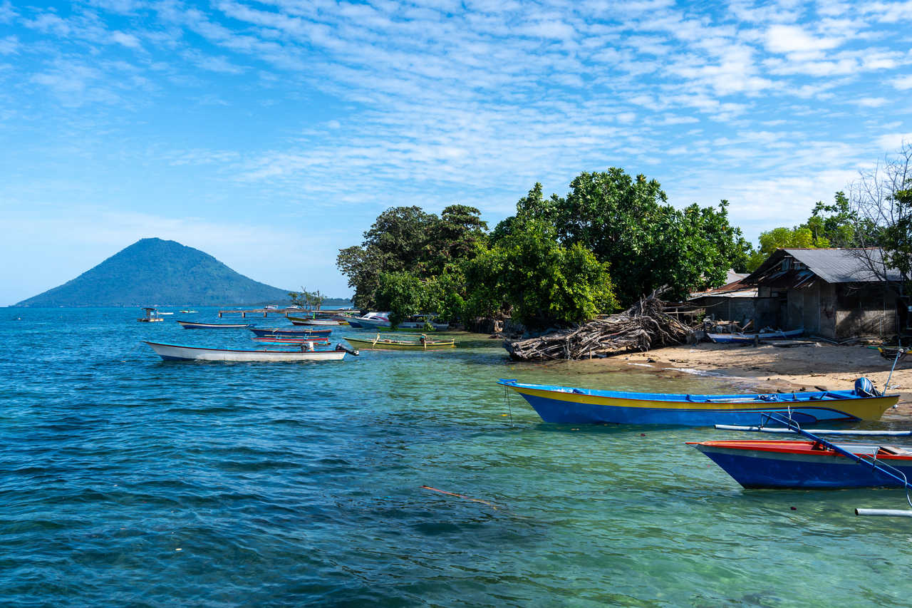 Petit port sur l'île de Bunaken, Sulawesi, Indonésie avec vue sur le volcan