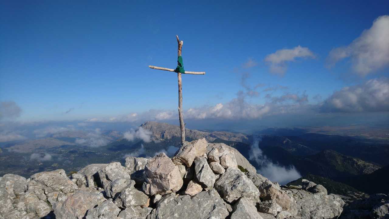 Croix en bois au sommet d'un montagne avec vue sur la mer et les montagnes au loin