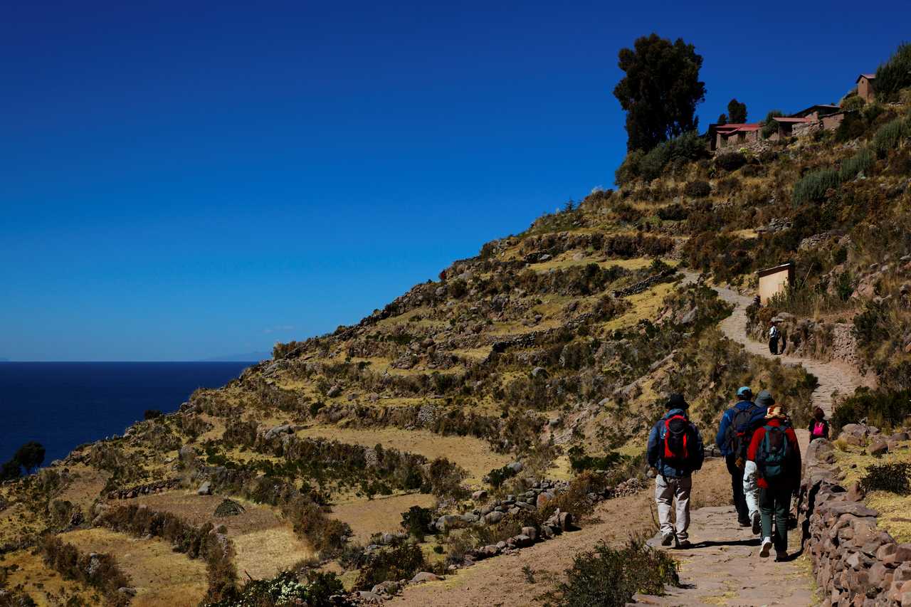 randonneurs au bord du lac Titicaca, au milieu des terrasses incas