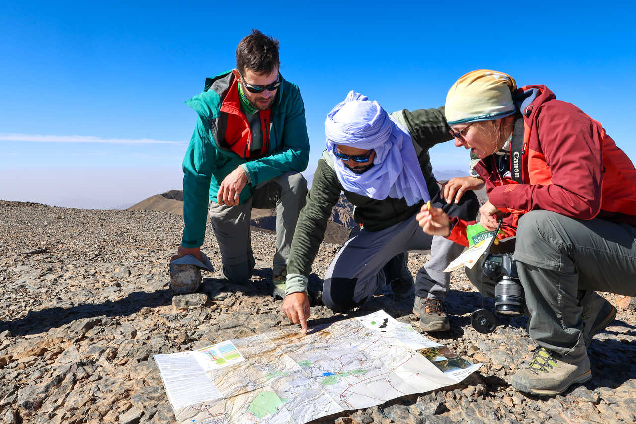 Randonneurs qui regarde une carte avec le guide dans l'Atlas marocain, Maroc