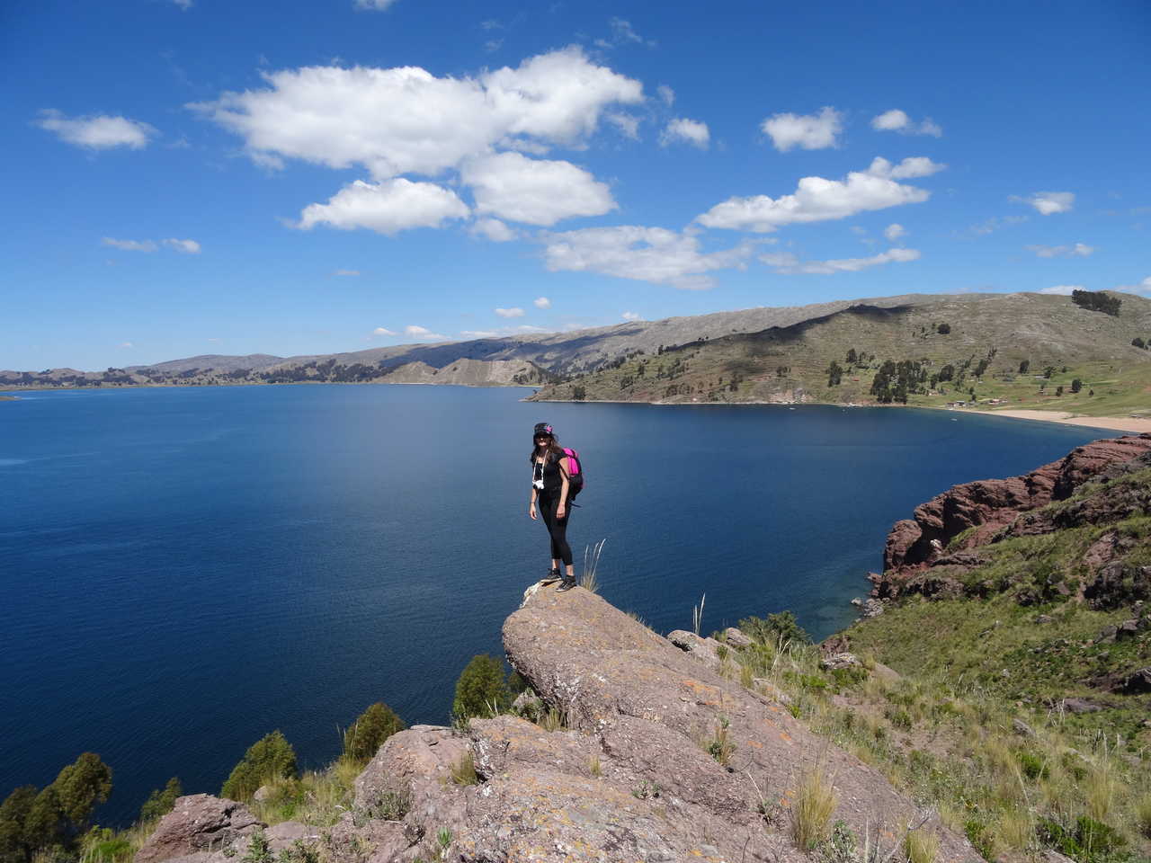 Randonneuse sur une pierre qui surplombe le lac Titicaca