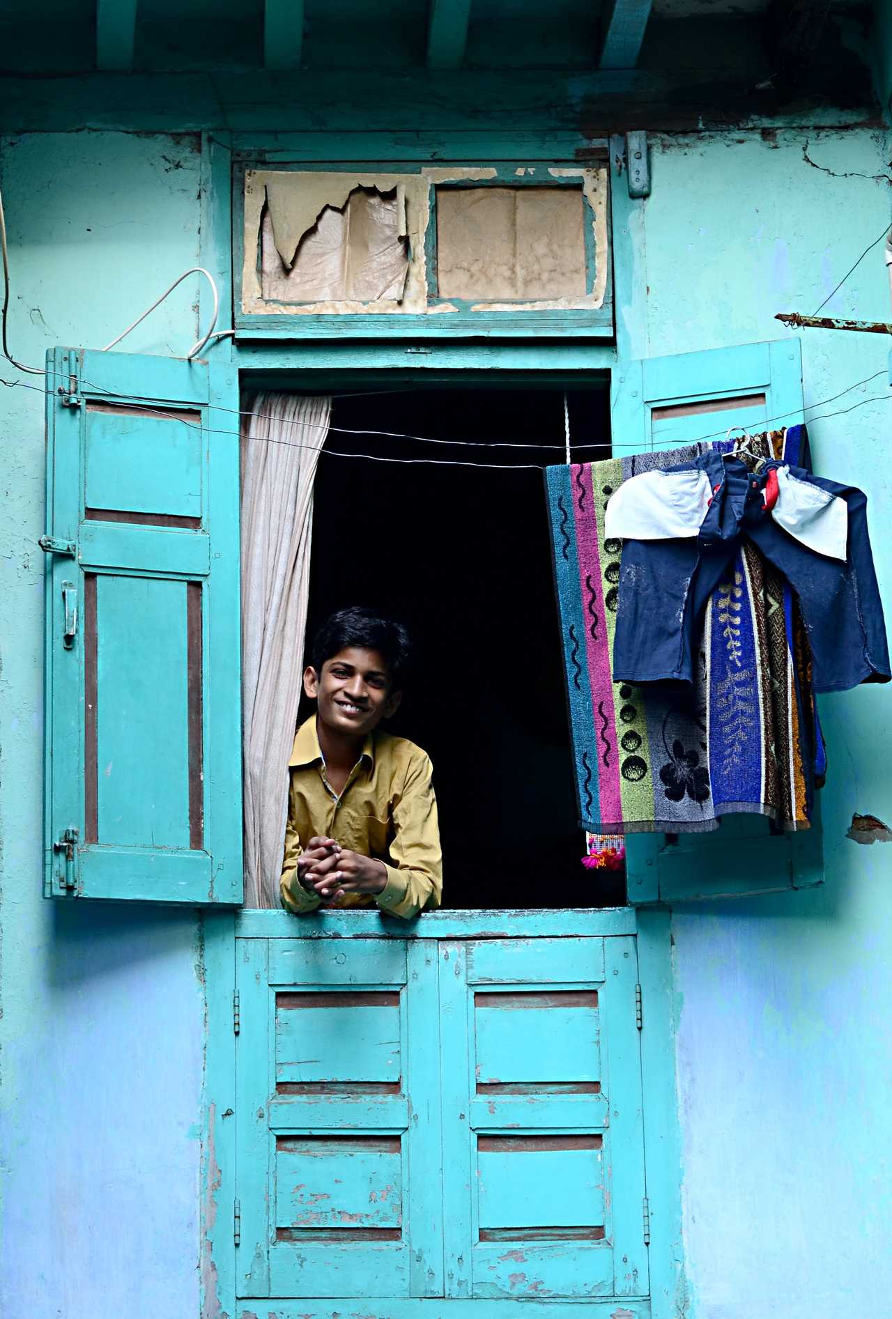 Un garçon indien regarde par la fenêtre