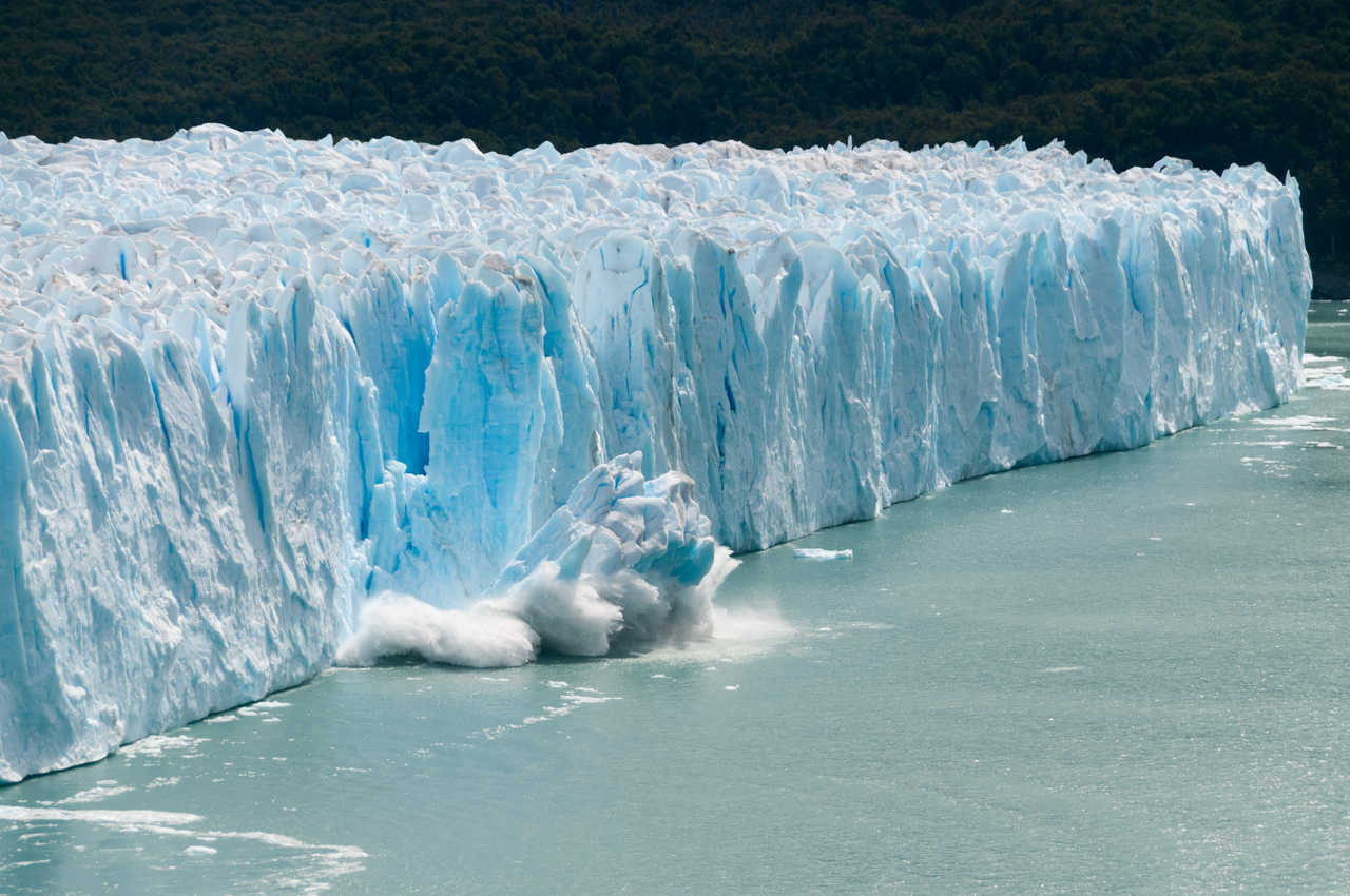 Un gigantesque bloc de glace bleue se détache et s'effondre avec fracas dans les eaux du lac Argentino depuis le front du glacier Perito Moreno en Patagonie.