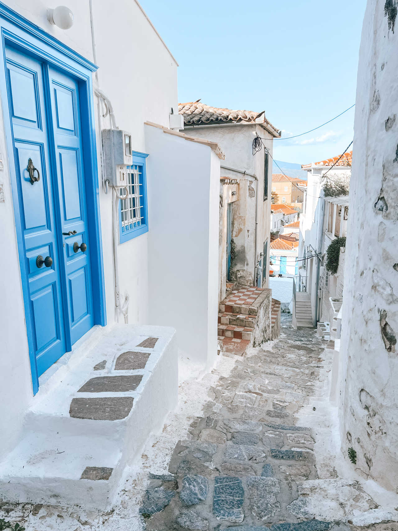 Vieille ville avec ses ruelles pavées étroites bordées de maisons blanches et de portes bleues sur l'île de Poros.