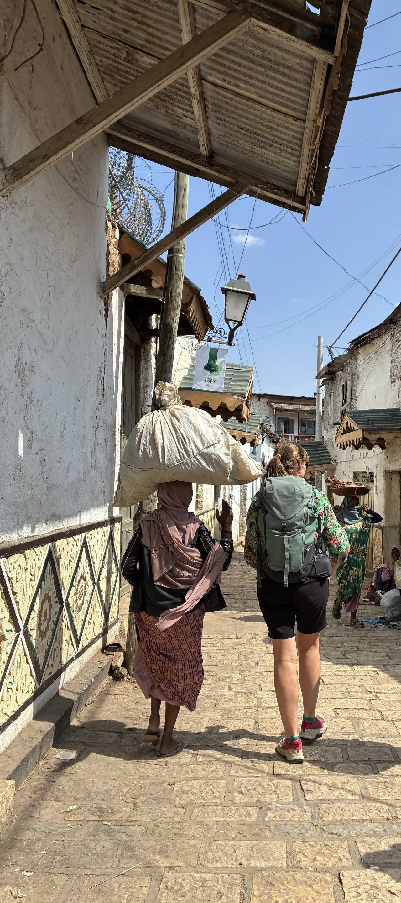 Voyageuse marchant avec une femme locale dans la cité d'Harar