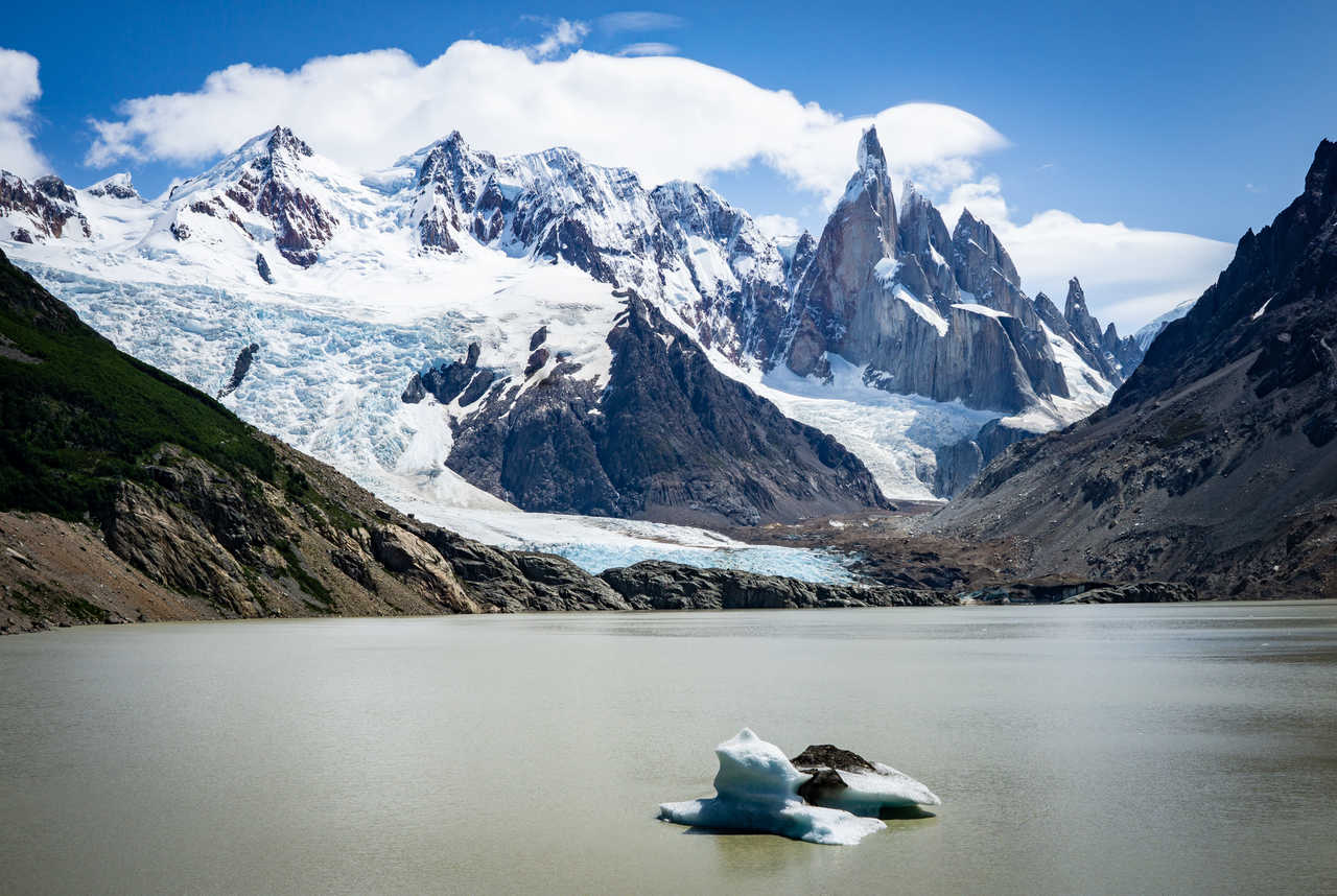Vue panoramique sur la Laguna Torre et son petit iceberg flottant, dominés par l'impressionnante aiguille de granit du Cerro Torre et le glacier Grande en Patagonie argentine, près d'El Chaltén