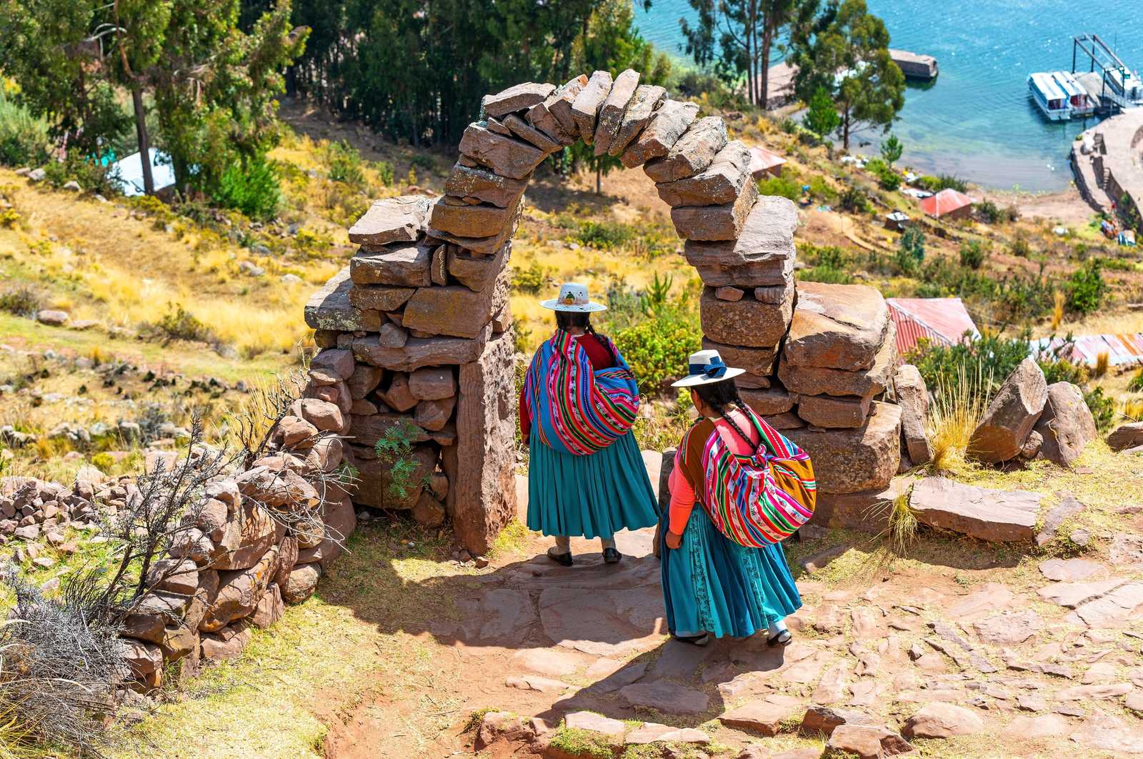 Femmes en tenue traditionnelle sous une arche à Taquile © Sl-Photography