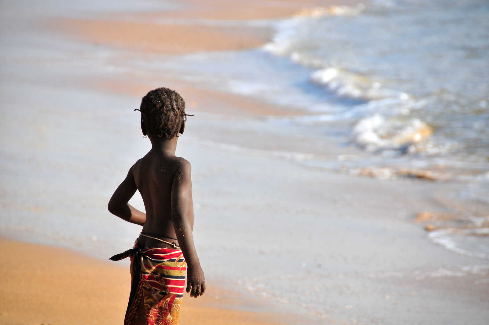 enfant face à la mer au sénégal © Adobe Stock