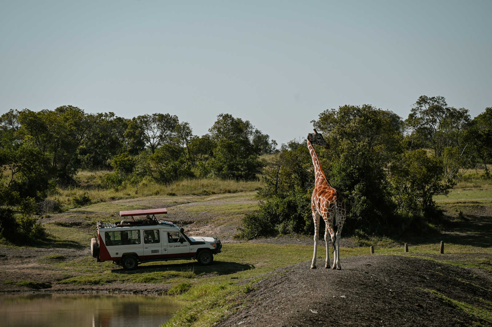 girafe devant un 4x4 Atalante pendant un safari au Kenya © Coudret Étienne