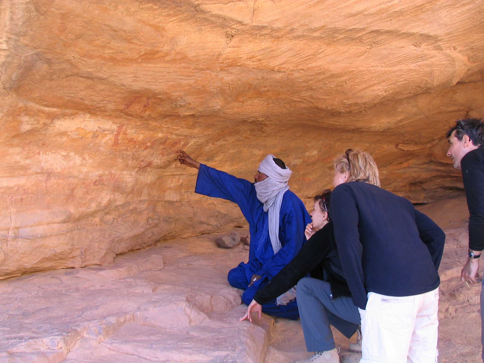 Guide montrant des peintures rupestres aux randonneurs dans le Tassili N'Ajjer, en Algérie © Petin Olivier