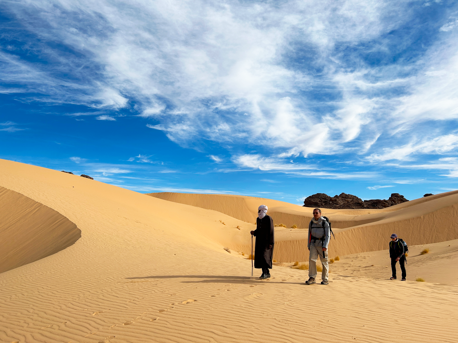 Petit groupe de randonneurs avec leur guide Touareg dans le désert, en Algérie © Dufy Caroline