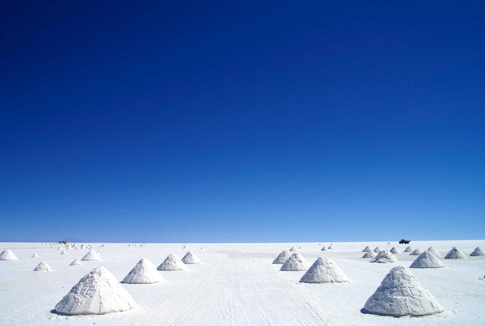 Pyramides de sel blanc séchant sous un ciel bleu intense dans le Salar d'Uyuni, étape emblématique du voyage en Bolivie. © Rest77