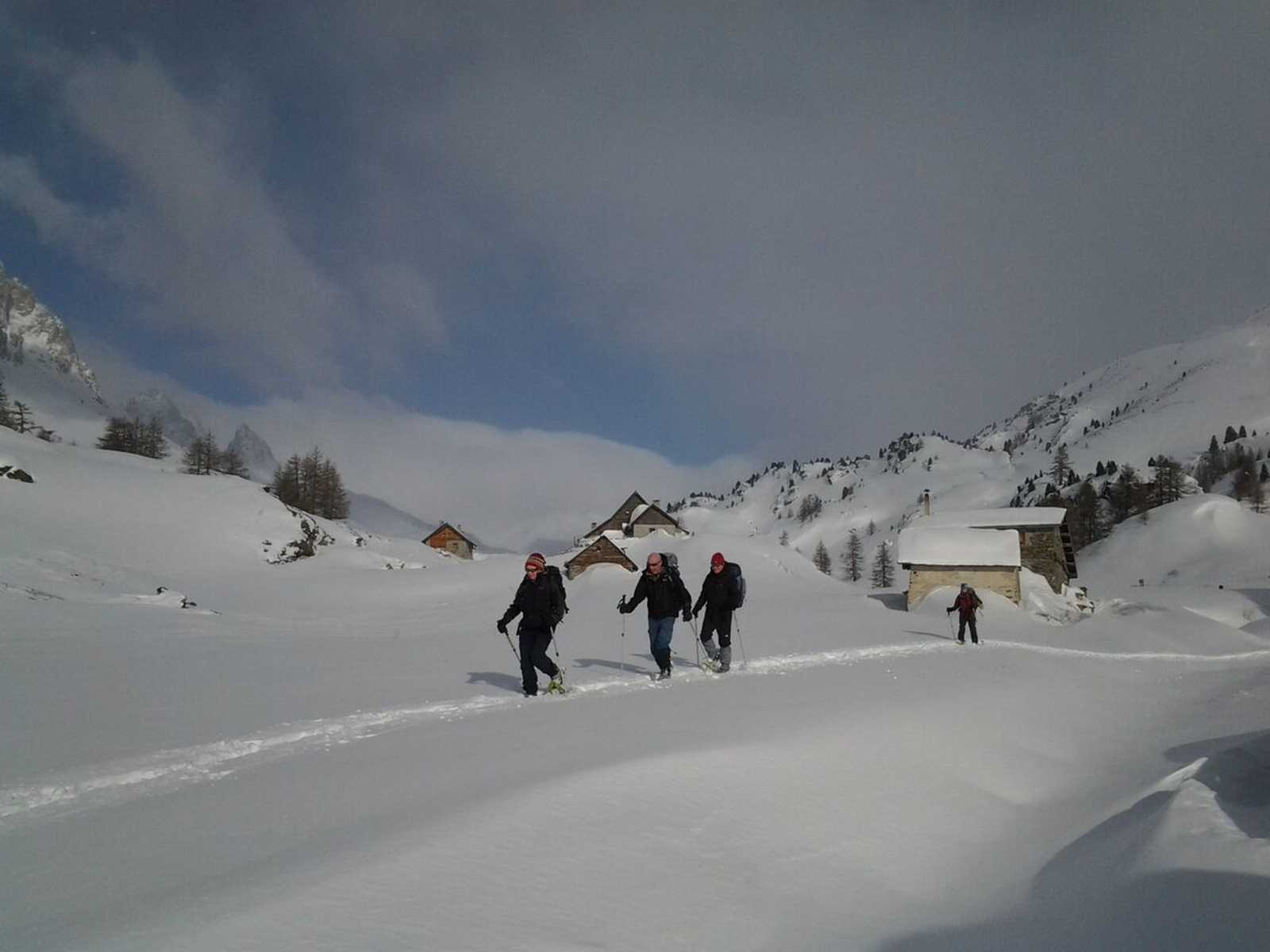 Randonneurs dans un hameau enneigé de la vallée de la Clarée, Alpes du sud © Destination Queyras