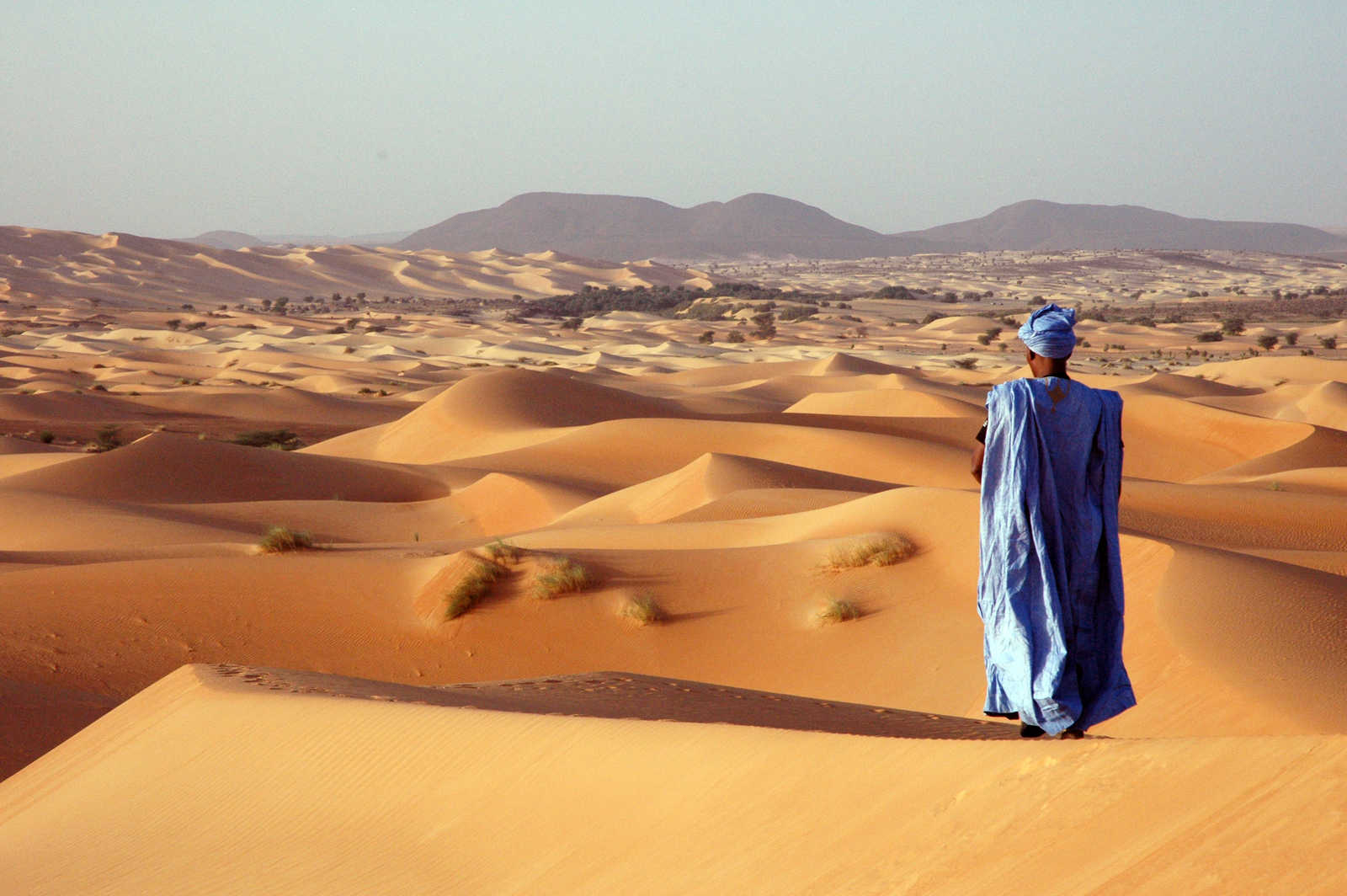 Touareg observant le coucher de soleil sur les dunes en Mauritanie © Martin Laprade Nicolas