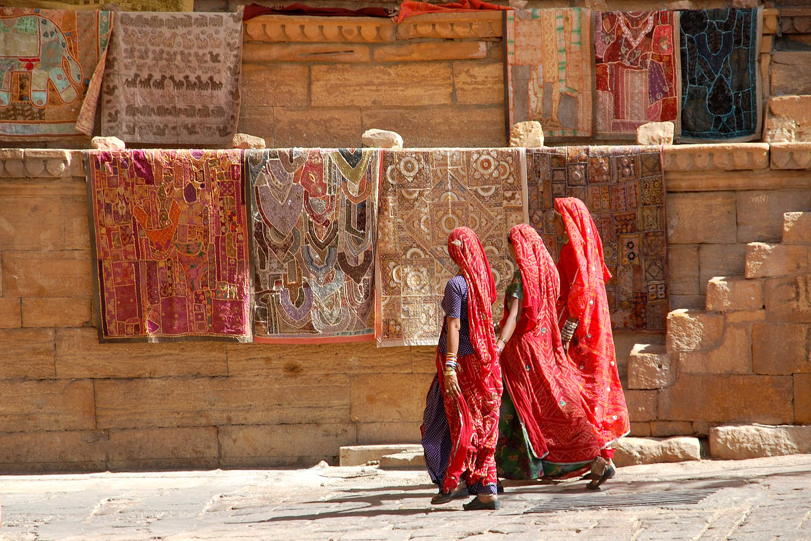 Trois indiennes en sari marchants devant un mur coloré, Rajasthan © Coston Jean-Pierre
