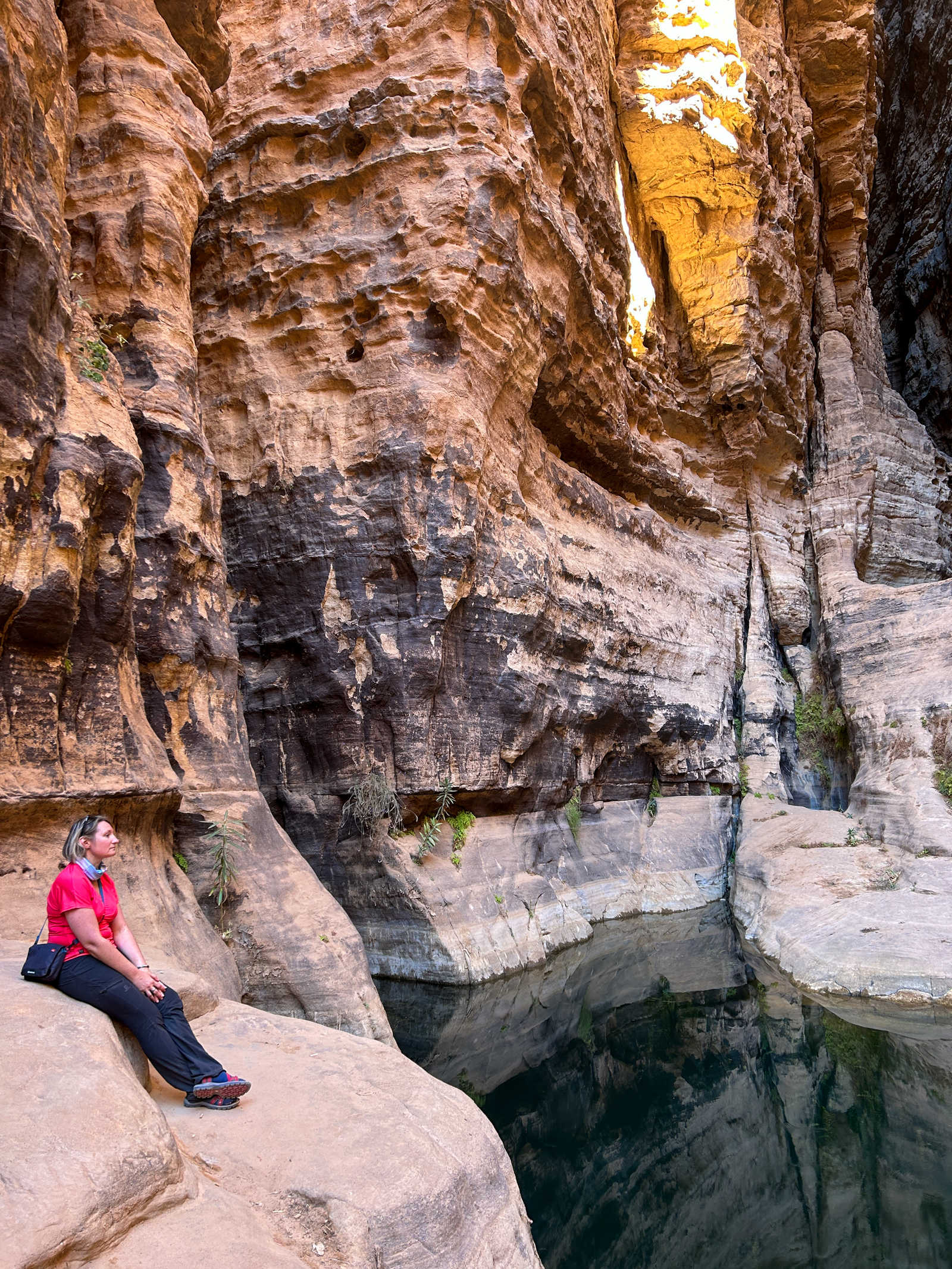 Voyageuse assise dans un canyon au bord de l'eau dans Tassili N'Ajjer, en Algérie © Ioan Benjamin