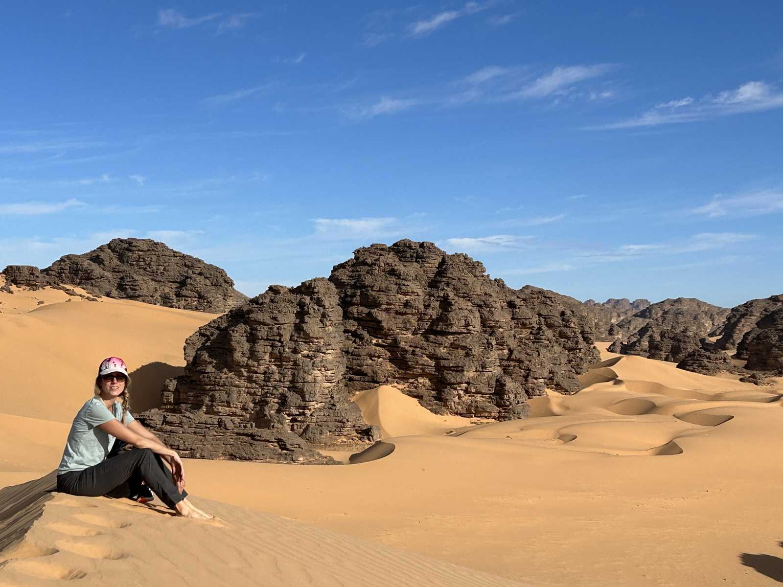 Voyageuse assise sur une dune dans le Tassili N'Ajjer, en Algérie © Dufy Caroline