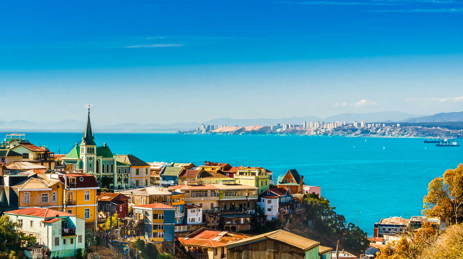 Vue sur les maisons multicolores des collines de Valparaiso avec l'église et la baie bleue de l'océan Pacifique © Streetflash