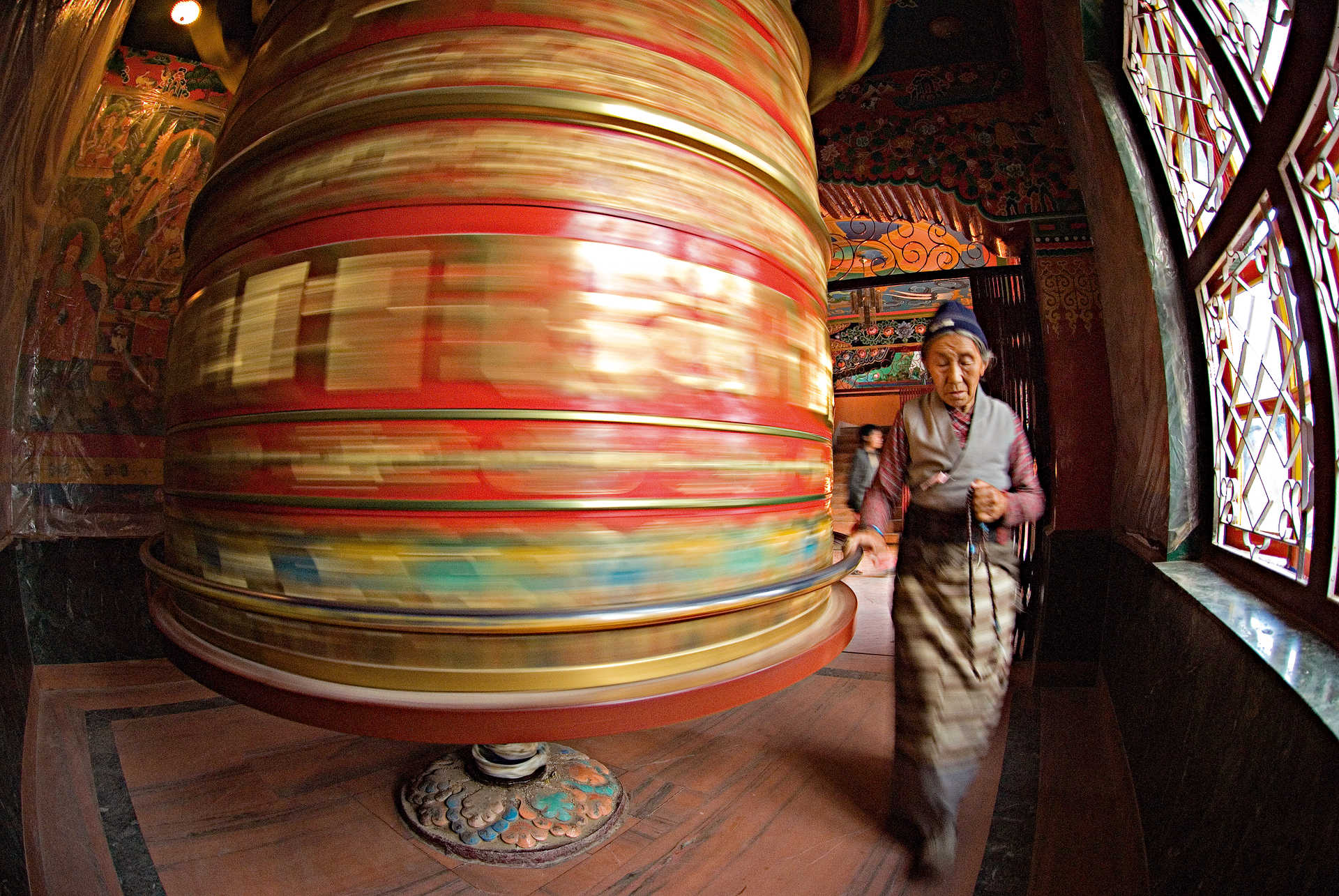 femme népalaise qui fait tourner une roue de prière au Népal