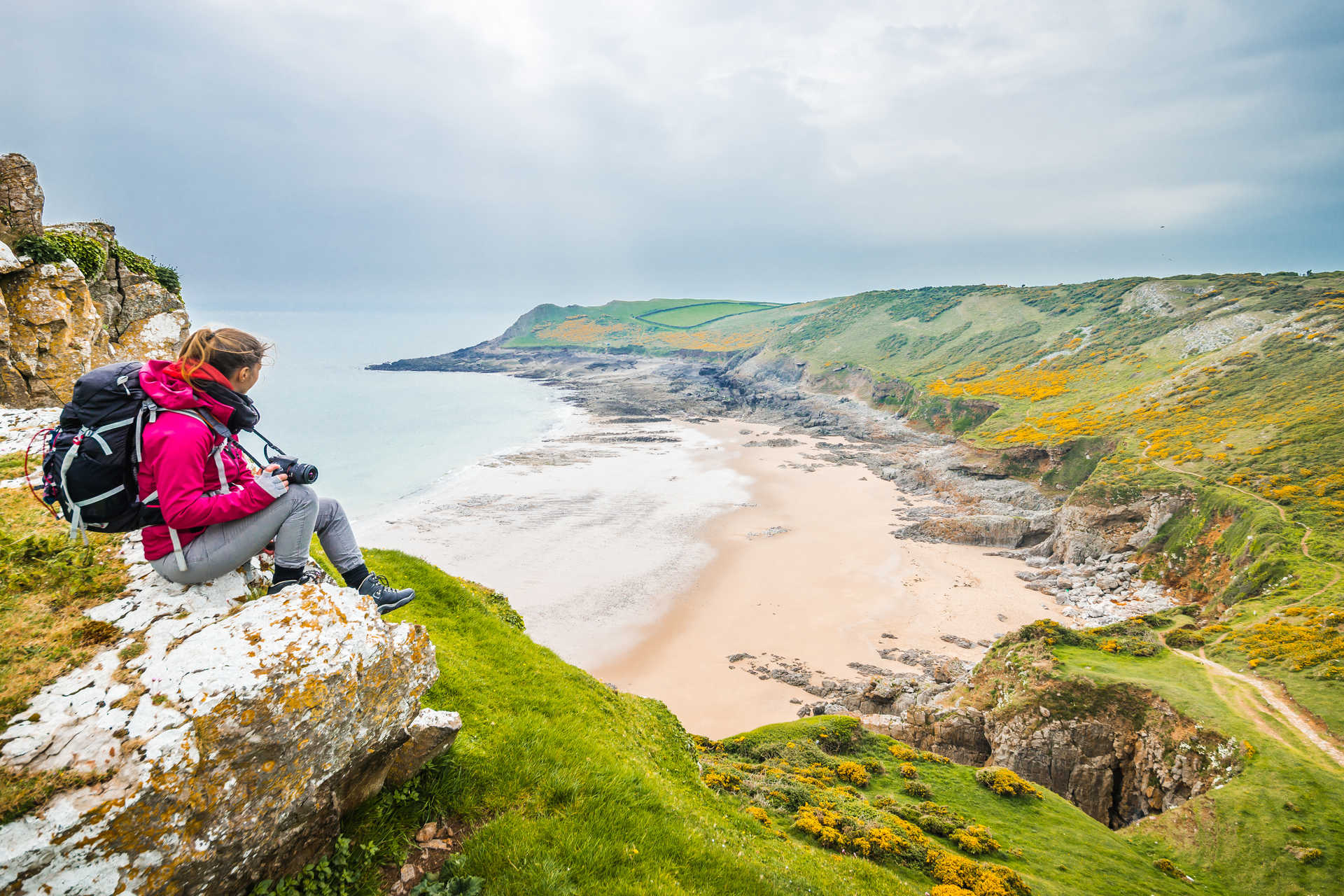 Femme sur le rocher admirant le paysage de Rocky Sea Shore, Pays de Galles