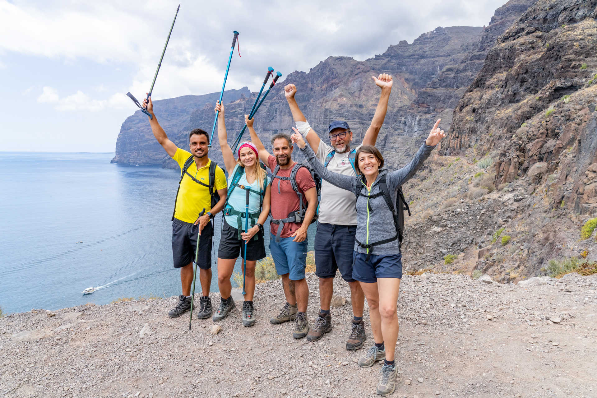 groupe de randonneurs qui lève les bras devant la falaise de los Gigantes sur l'ile de Tenerife