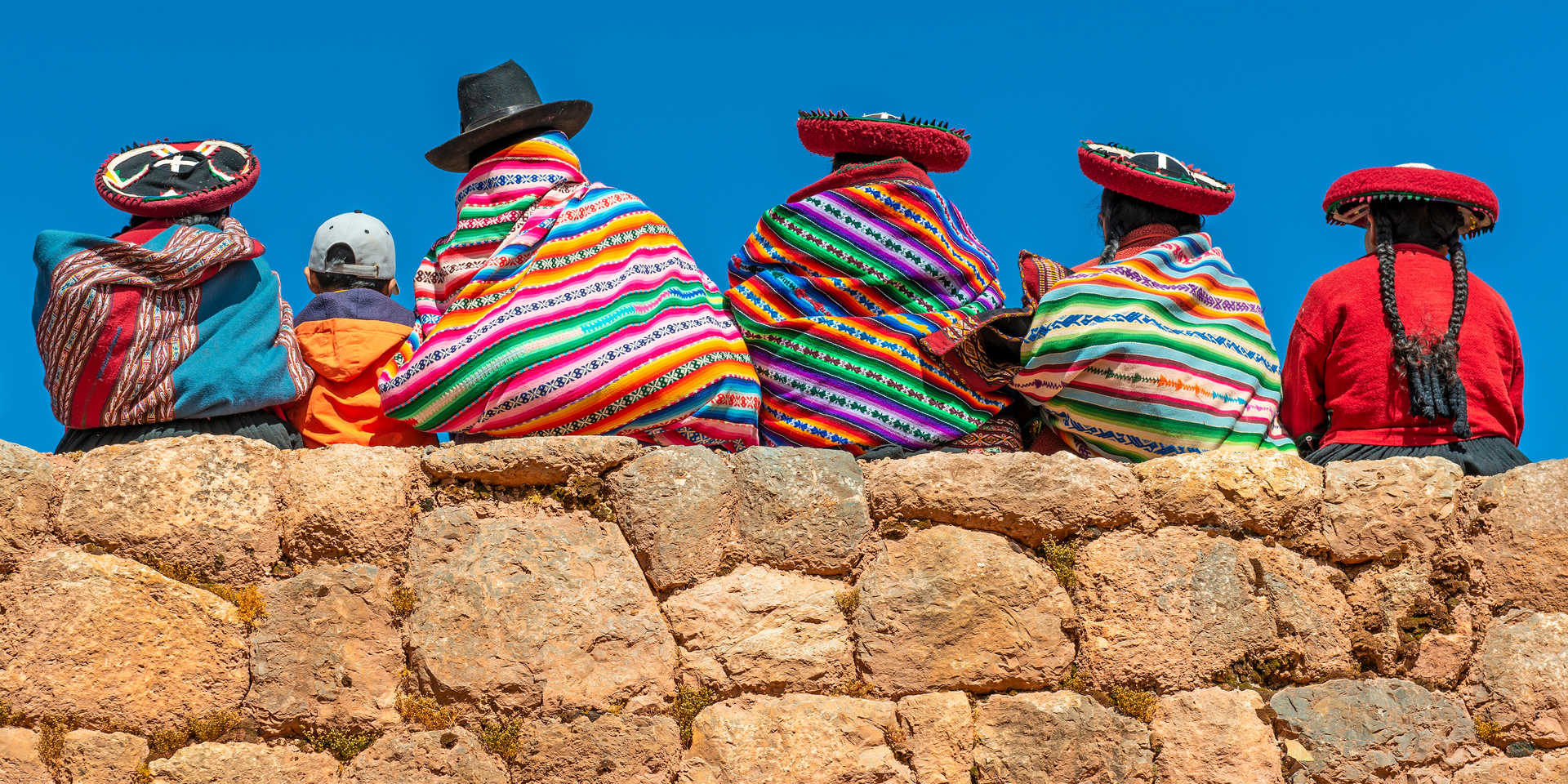 Indigènes quechuas du Pérou en vêtements traditionnels sur un mur inca à Chinchero, Cusco, Pérou.