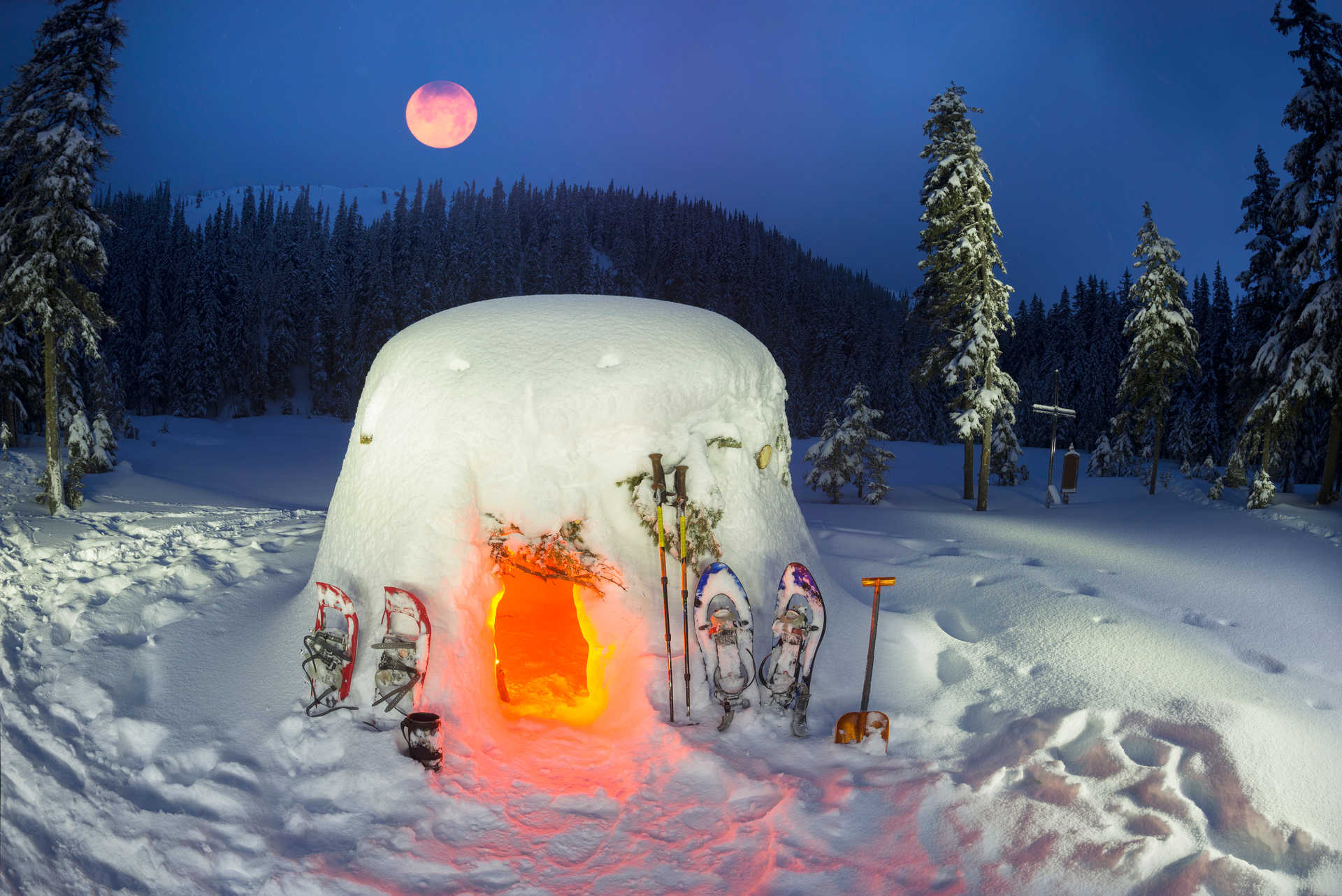 Montagne enneigée au clair de lune avec igloo et raquettes à neige