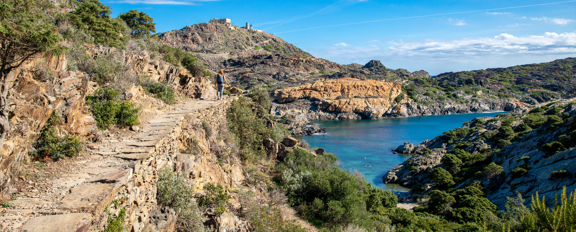 Randonneuse avec vue panoramique sur plage, falaise et phare - Costa brava en Espagne