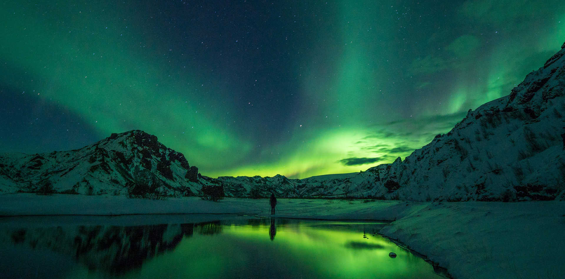 Voyageur en Islande, contemplant une aurore boréale verte