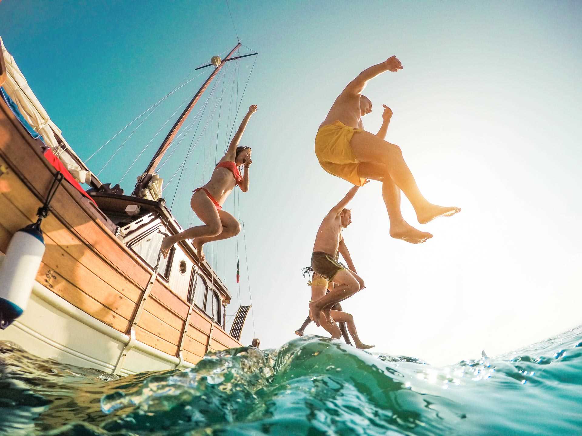 Voyageurs sautant d'un bateau dans la mer