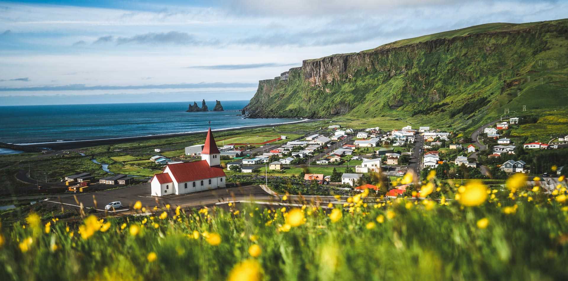 Vue sur le petit village de Vik et sur les trolls de Reynisdrangar, en Islande