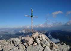 Croix en bois au sommet d'un montagne avec vue sur la mer et les montagnes au loin Pico de Tossals Verds aux Baléares