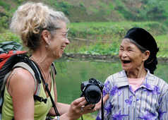 Femme échangeant et riant avec une femme des minorités ethniques du Nord Vietnam