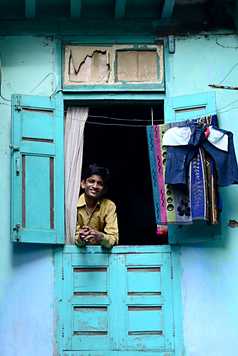 Un garçon indien regarde par la fenêtre