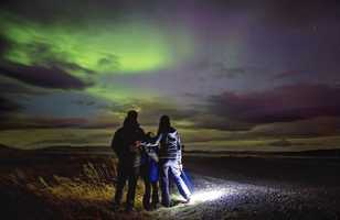 Famille admirant un aurore boréale en Islande