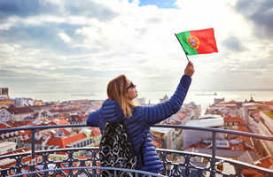 Jeune femme touriste tenant le drapeau du Portugal dans ses mains à Lisbonne